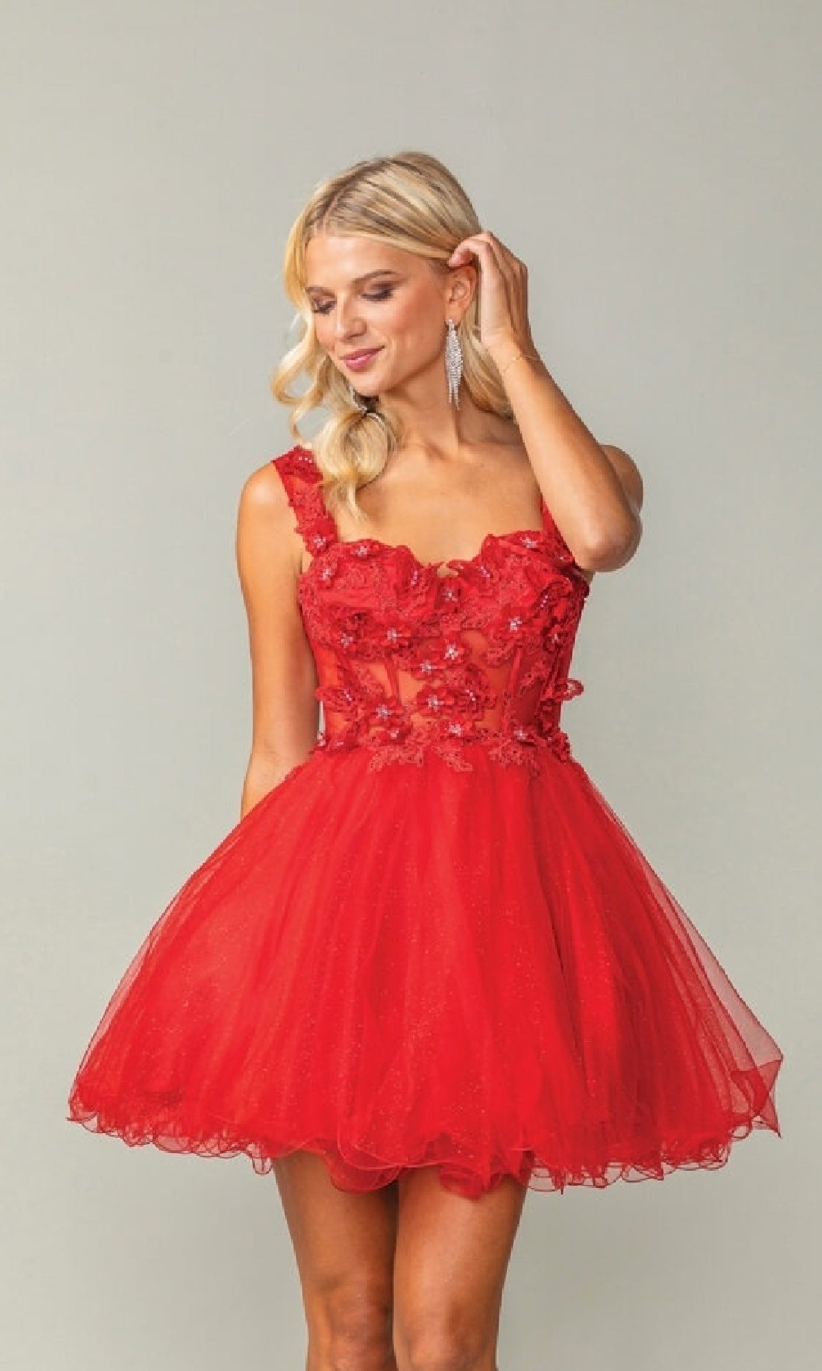 Woman wearing a red a-line short dress with floral details on a gray background